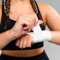 Free photo close-up woman bandaging her hands front view