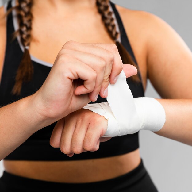 Close-up woman bandaging her hands front view