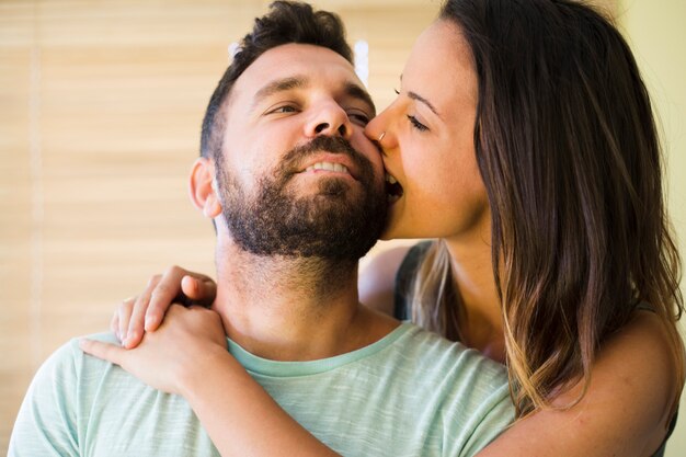 Close-up of a woman biting her husband cheek