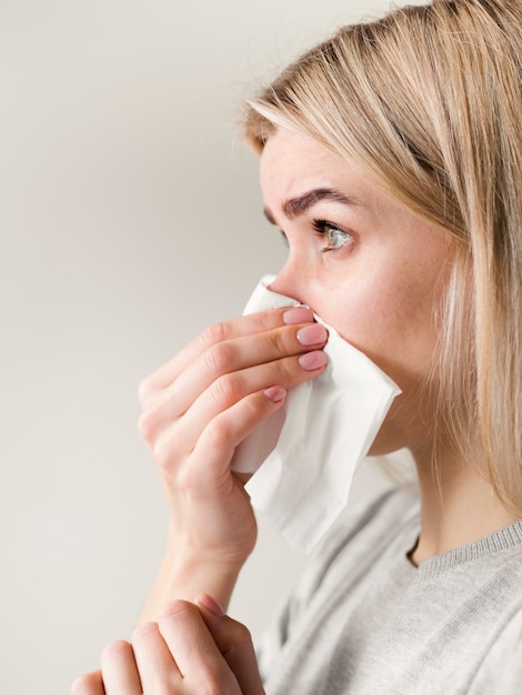 Free photo close-up woman blowing nose