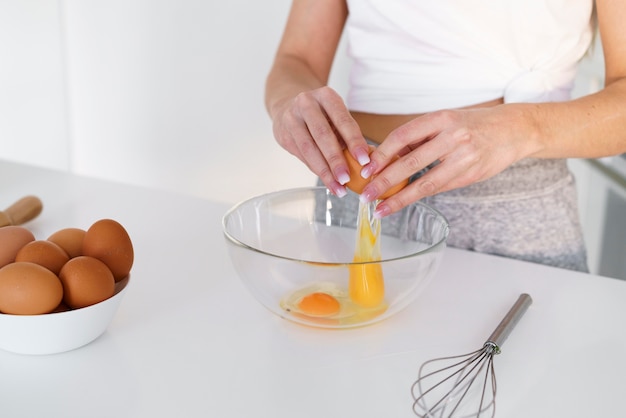 Close-up woman breaking eggs