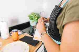 Foto gratuita primo piano della donna che rompe il pacchetto di pasta in cucina