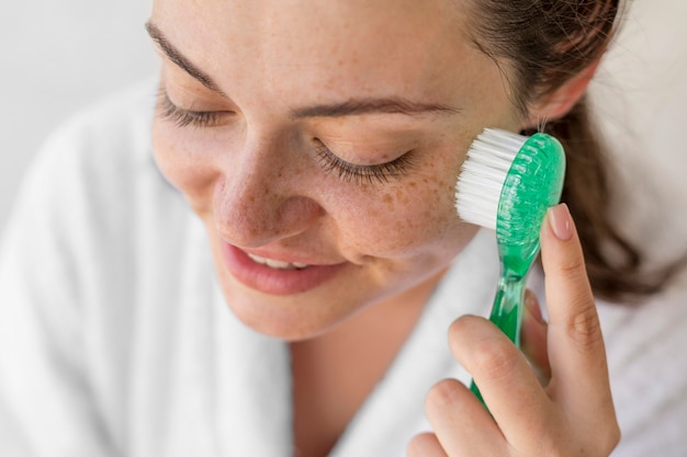 Close-up woman brushing face