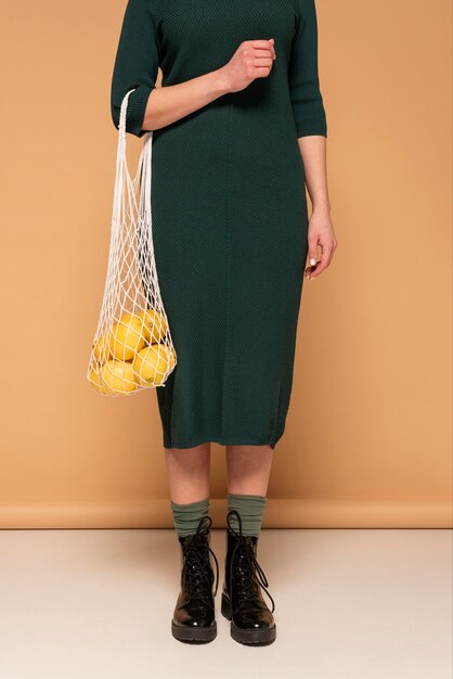 Крупным планом женщина в повседневной одежде, несущая многоразовую сумку с черепахой