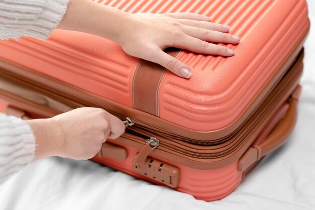 Close up woman closing luggage