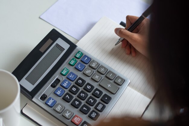 Close-up of woman counting figures while preparing tax
