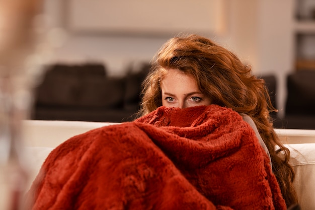 Бесплатное фото Крупным планом женщина, покрывающая себя одеялом