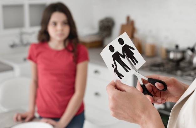 Close-up woman cutting family paper with scissors