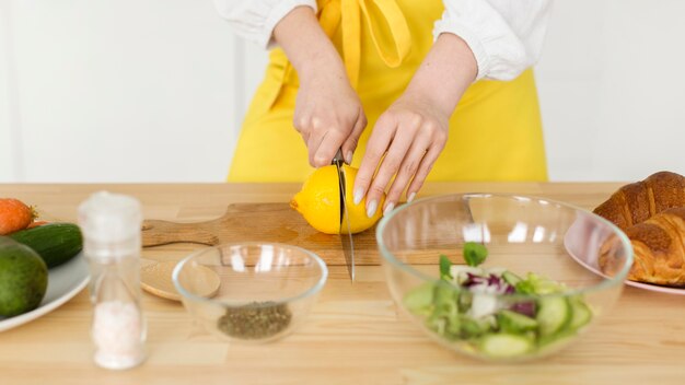 Close-up woman cutting lemon