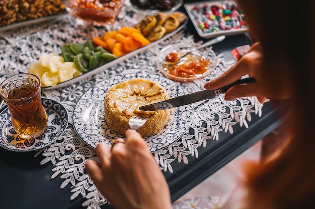 Close up of woman cutting portioned pear pie served for tea