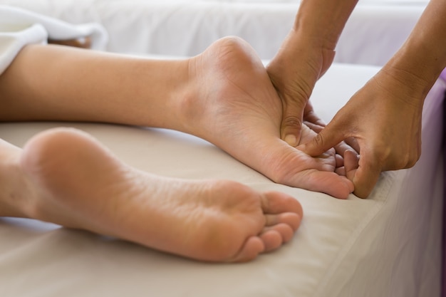 Close-up of woman doing foot massage at spa.