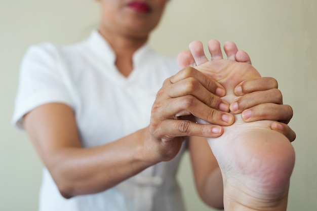 Close-up of woman doing foot massage at spa.