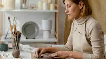 Free photo close-up woman doing pottery at home