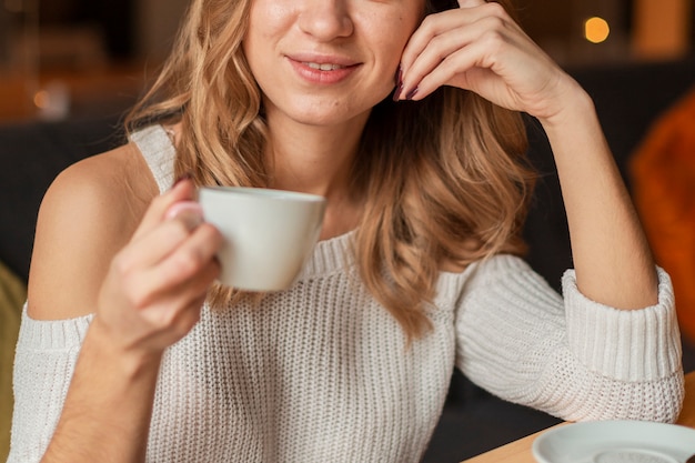 Крупным планом женщина пьет чашку кофе