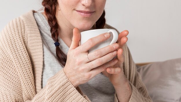 熱いお茶を飲むクローズアップ女性