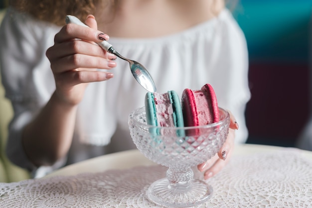 Close-up of woman eating delicious frozen ice cream dessert with spoon