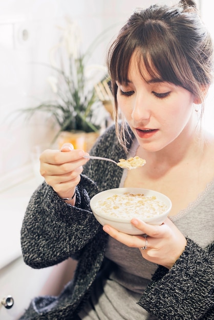 Close-up of a woman eating oat with milk