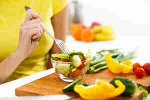 Free photo close-up of a woman eating salad in the kitchen