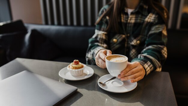 コーヒーブレイクを楽しんでいる女性のクローズアップ