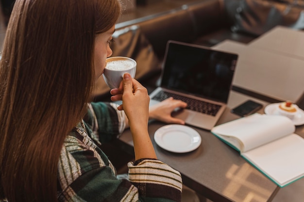 コーヒーカップを楽しんでいる女性のクローズアップ