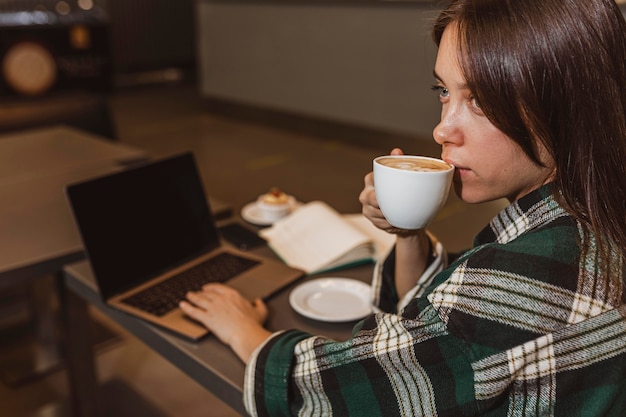 Foto gratuita primo piano di una donna che gode di una tazza di caffè