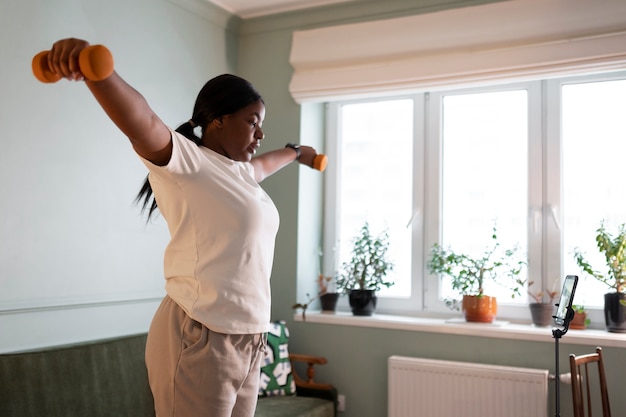 Close up on woman exercising after online instructor