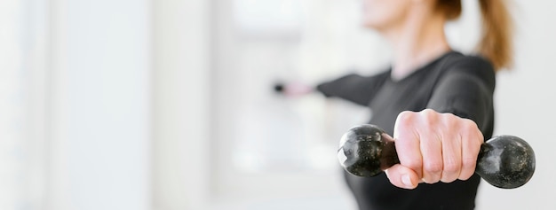 Free photo close-up woman exercising with dumbbell