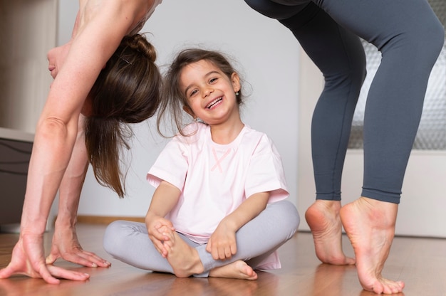 Close up woman exercising with girl