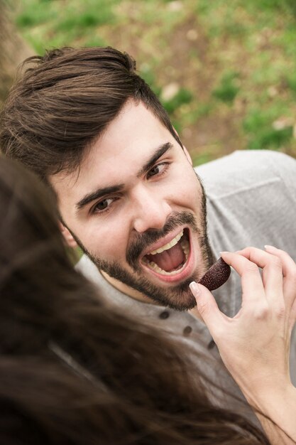 Primo piano della donna che alimenta la fetta di prugna al suo fidanzato