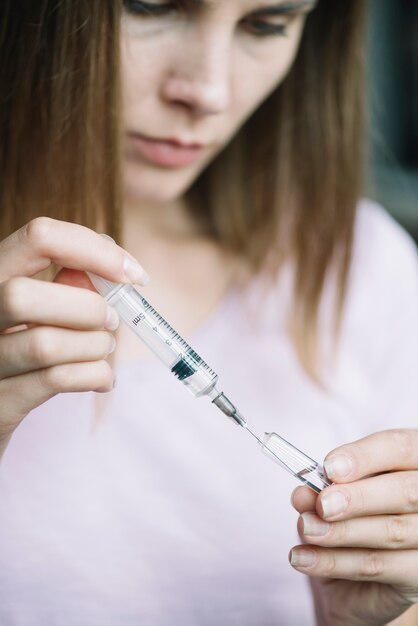 Close-up of a woman filling syringe with medicine