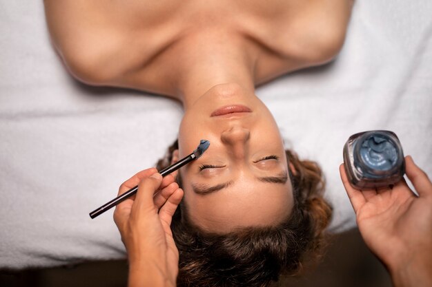 Close up woman getting face treatment