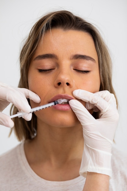 Close up woman getting lip filler at clinic