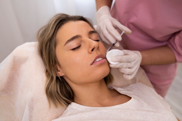 Close up woman getting lip filler at clinic