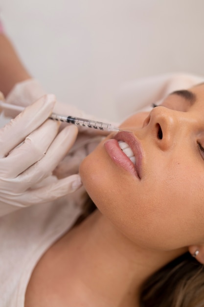 Close up woman getting lip filler with injection