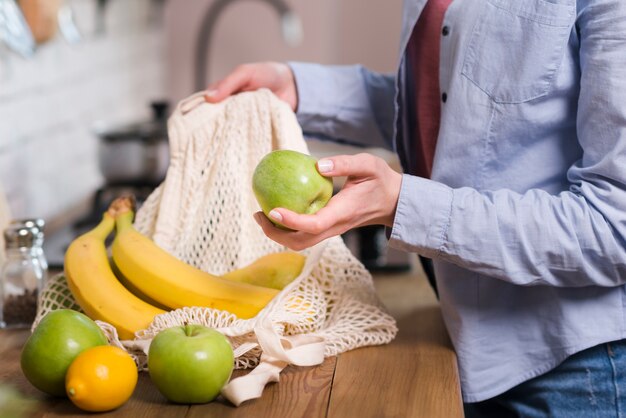 Close-up woman getting organic fruits out of eco bag