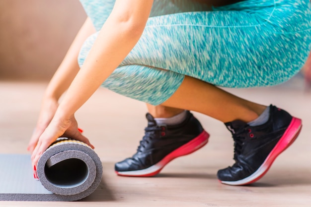 Free photo close-up of a woman hand folding exercise mat