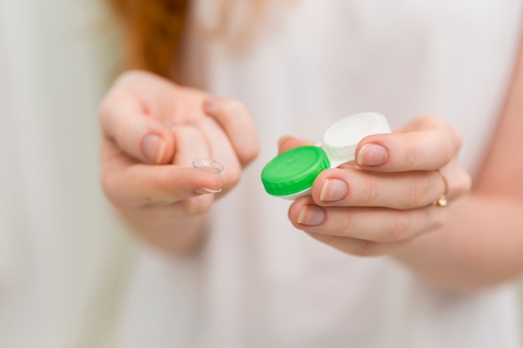 Free Photo close-up of woman hand holding contact lens and it's container