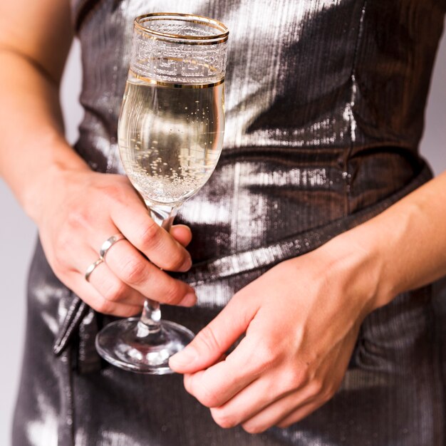Крупным планом женщина рука освежающий бокал с шампанским
