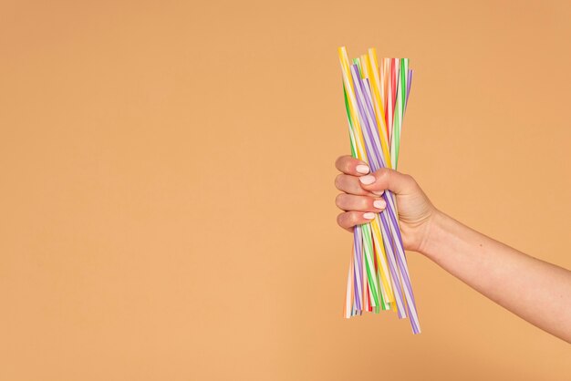 Close up woman hand with plastic straws