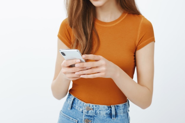 Close-up of woman hands holding mobile phone, texting message or scrolling through application