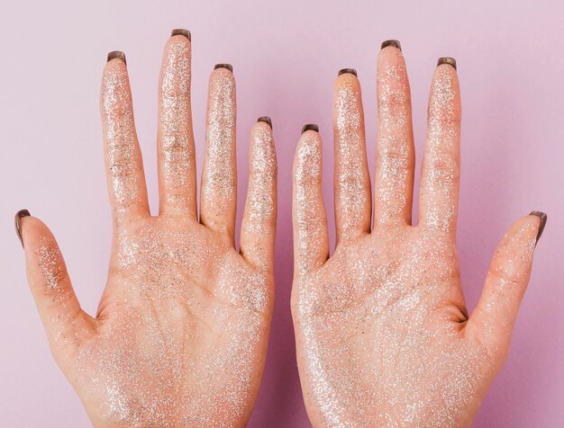 Close-up woman hands with silver glitter top view