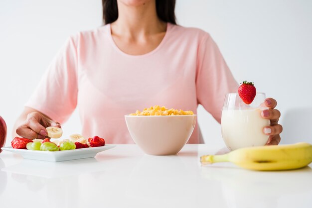 Close-up of woman having healthy breakfast on white desk