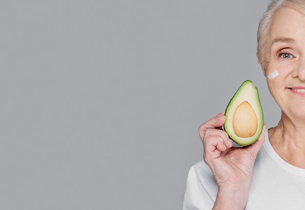 Free photo close-up woman holding avocado with copy-space