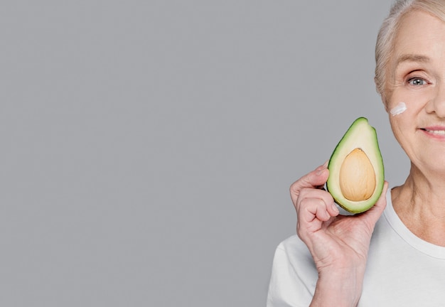 Close-up woman holding avocado with copy-space