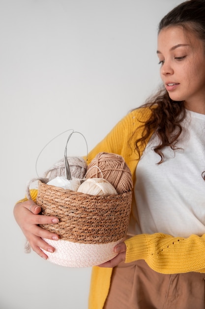Close up woman holding basket with yarns