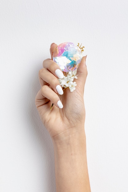 Close-up woman holding beautiful crystal and flower