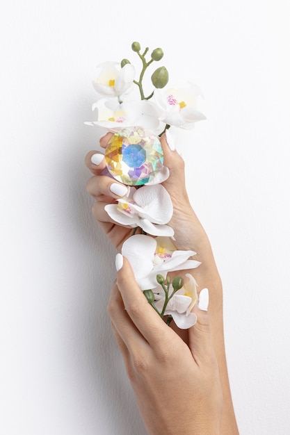 Free photo close-up woman holding beautiful flower and crystal