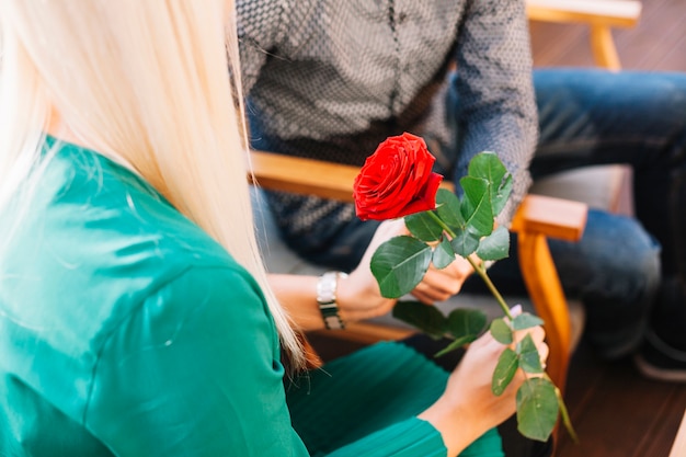 Foto gratuita primo piano della donna che tiene bella rosa rossa