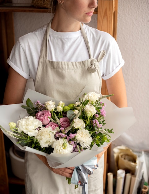 Крупным планом женщина, держащая букет