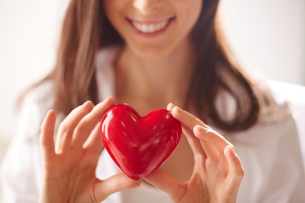 Close-up of woman holding a bright heart